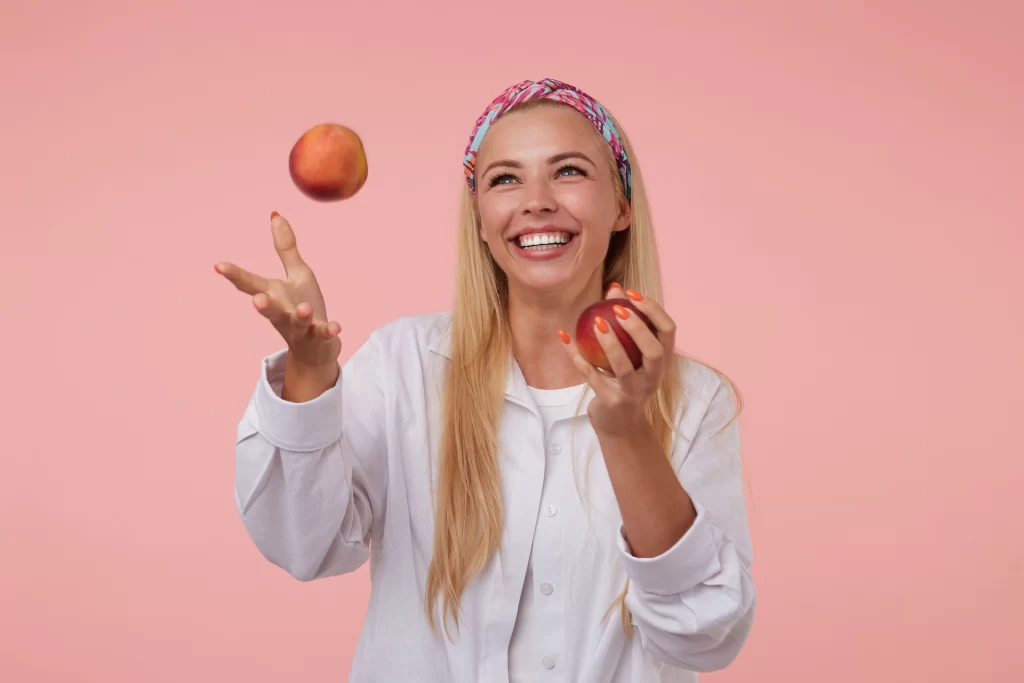 Woman juggling peaches