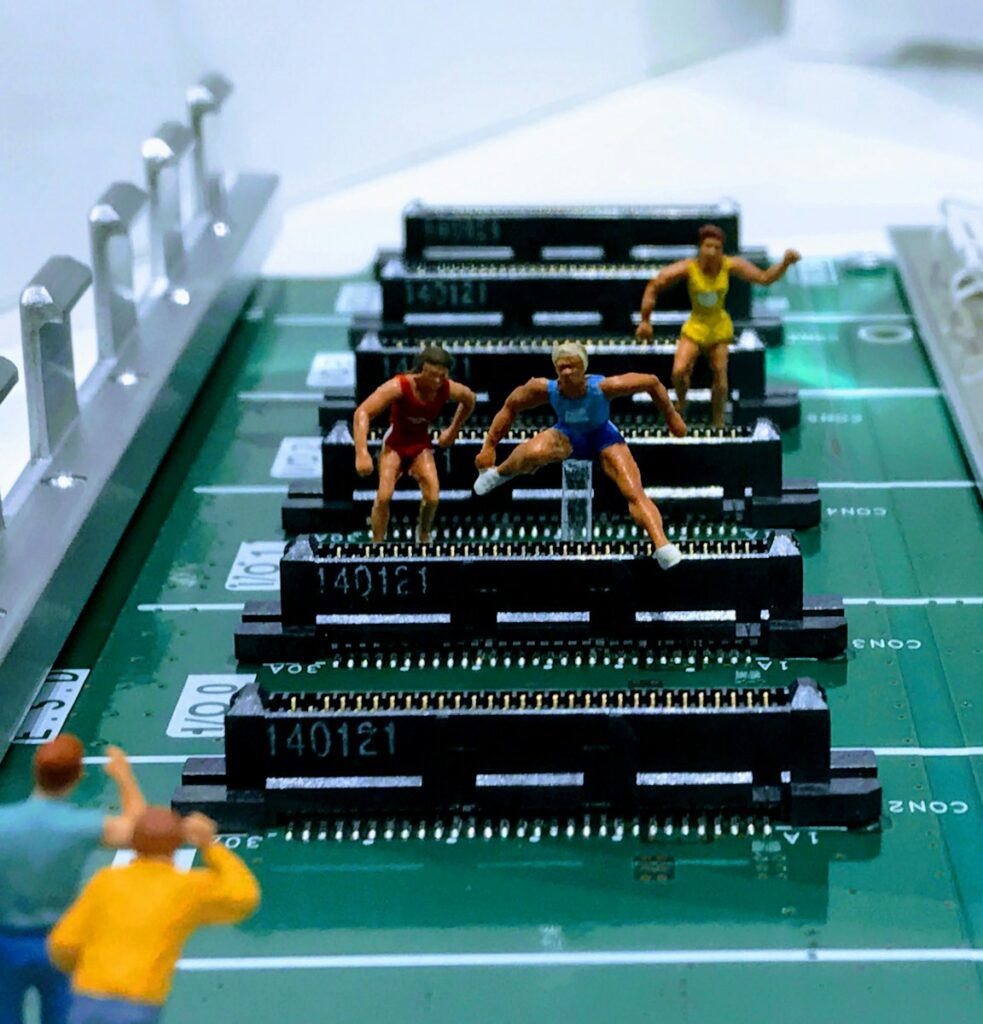 An image depicting athletes jumping over transistors as if they are hurdles